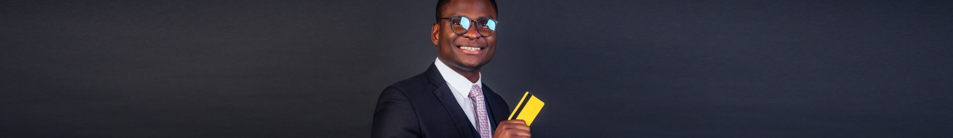 A man wearing suit and holding a credit card